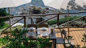 An outdoor dining area with tables set for two, overlooking a rocky coastline. - Casa Frontemare con Scesa al Mare Privata (Castiglioncello (LI))