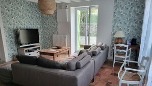 Una sala de estar con sofá, televisión y una mesa con un cuenco.