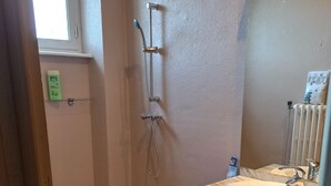 Un bagno con doccia, lavandino e WC.