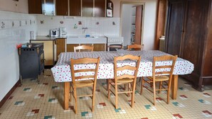 Una cucina con tavolo, sedie e fornello.