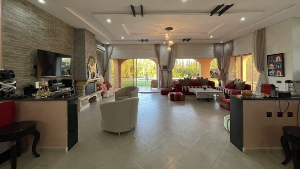 A spacious living area with a fireplace, a sofa set, and a television. - The Lemon Tree (Ainjohra)