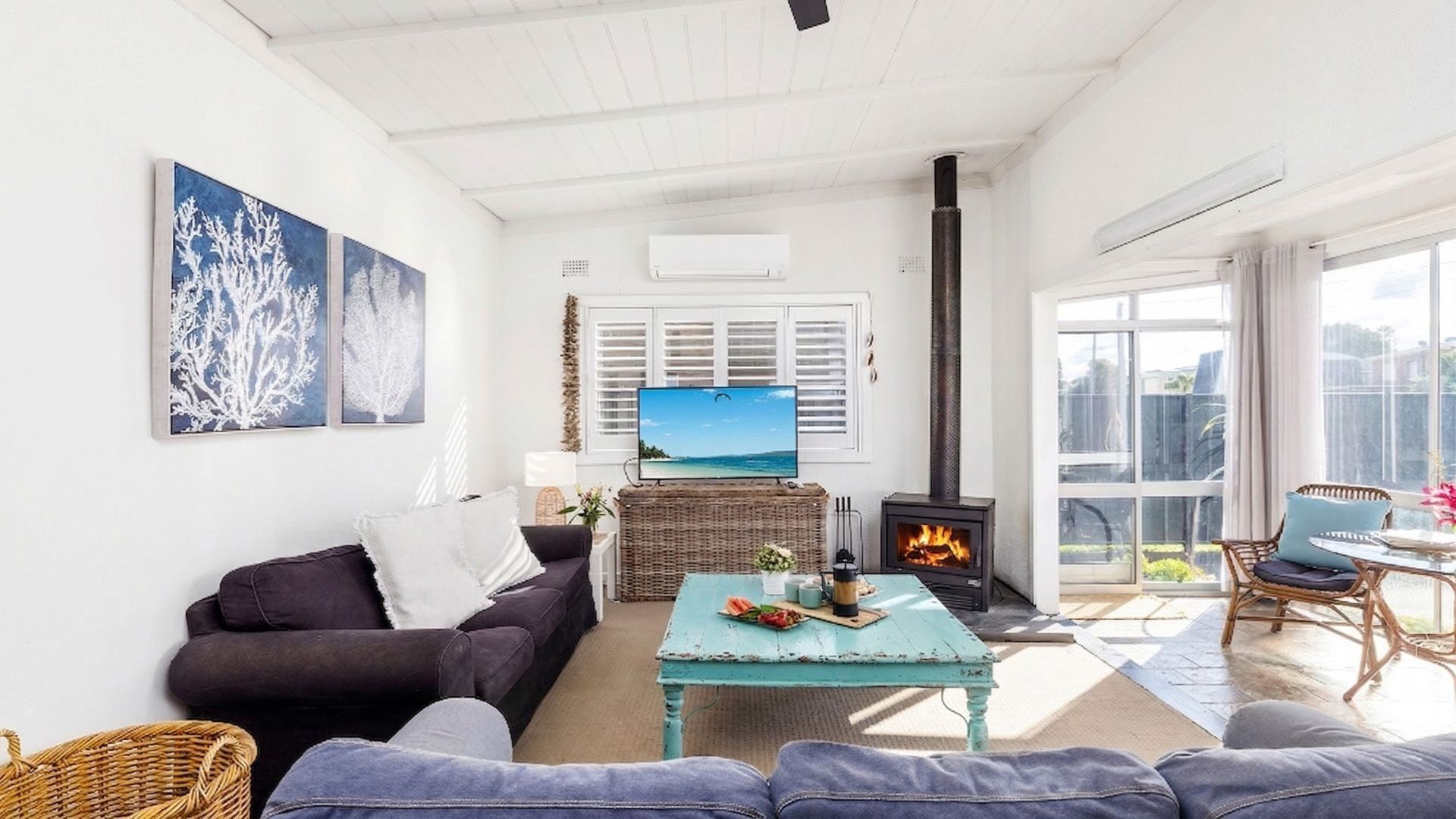 A cozy living room with a fireplace, comfortable seating, a television, and artwork on the walls.