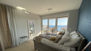 A bedroom with a bed, a window with a view, a chair, and a small table. - Modern Villa with Pool & Sea View-40m to the Beach (Lun)