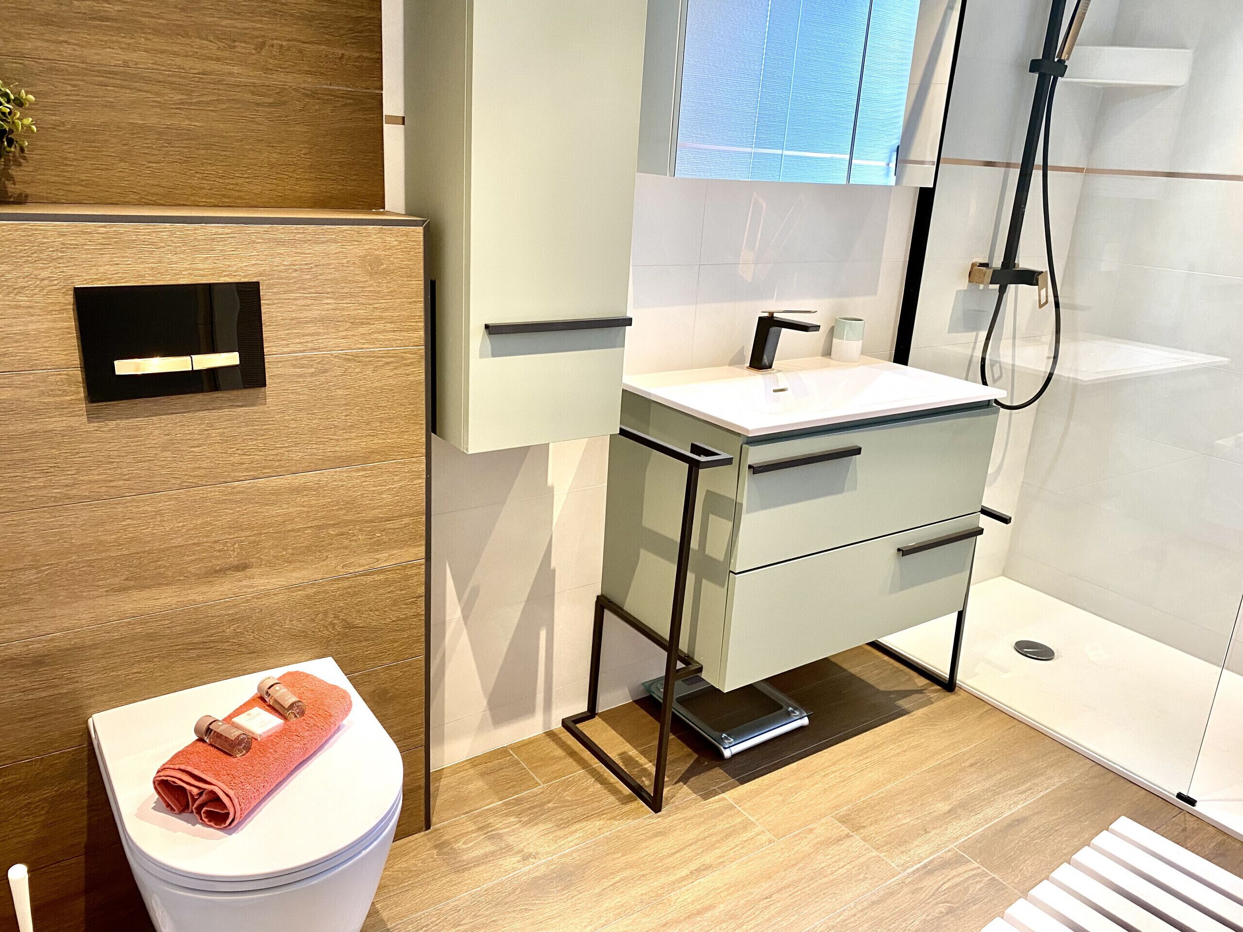 A modern bathroom with a toilet, sink, and shower area.