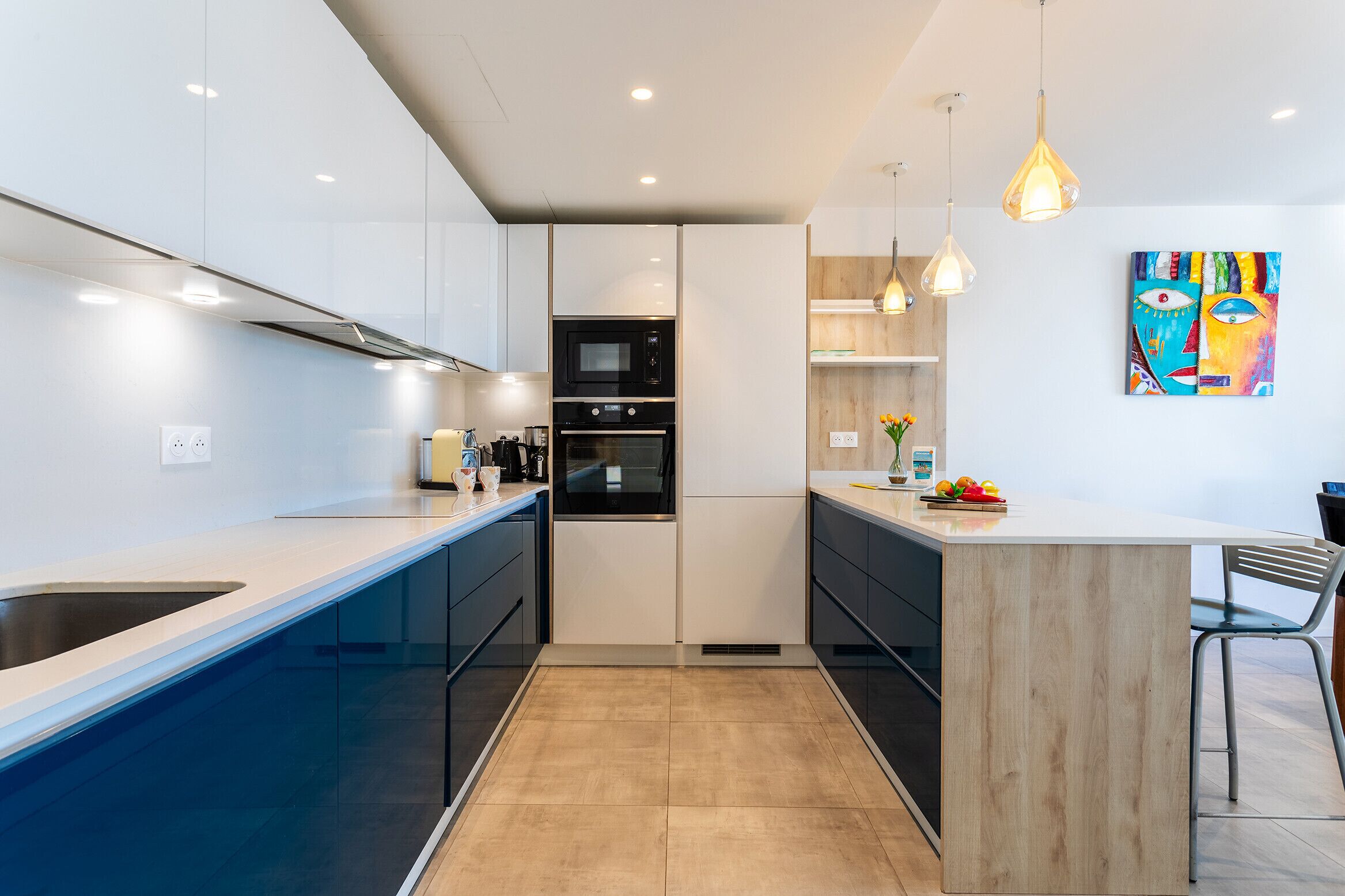 Een moderne keuken met witte kasten, een inbouwoven en een houten kookeiland met een barstoel.