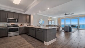 A modern kitchen with dark cabinetry, stainless steel appliances, and a large island. - New Complex! Lazy River/Slide! Penthouse Level! (Orange Beach)