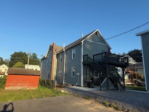 A two-story house with a balcony, a garage, and a red shed.