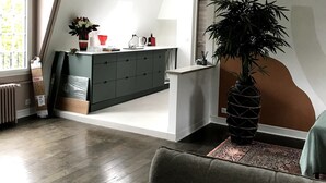 Een modern loft appartement met keuken, woonruimte en een groot raam.