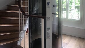 Een spiraaltrap met een glazen liftput.