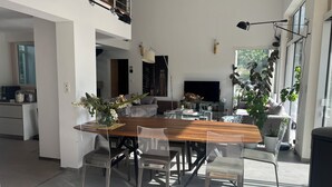 A modern open-plan living space with a dining area, kitchen, and seating area.