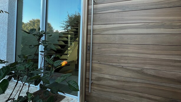 A modern building with large windows and a wooden door.