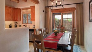 Un espace repas avec une table en bois, des chaises et une vue sur l’extérieur.