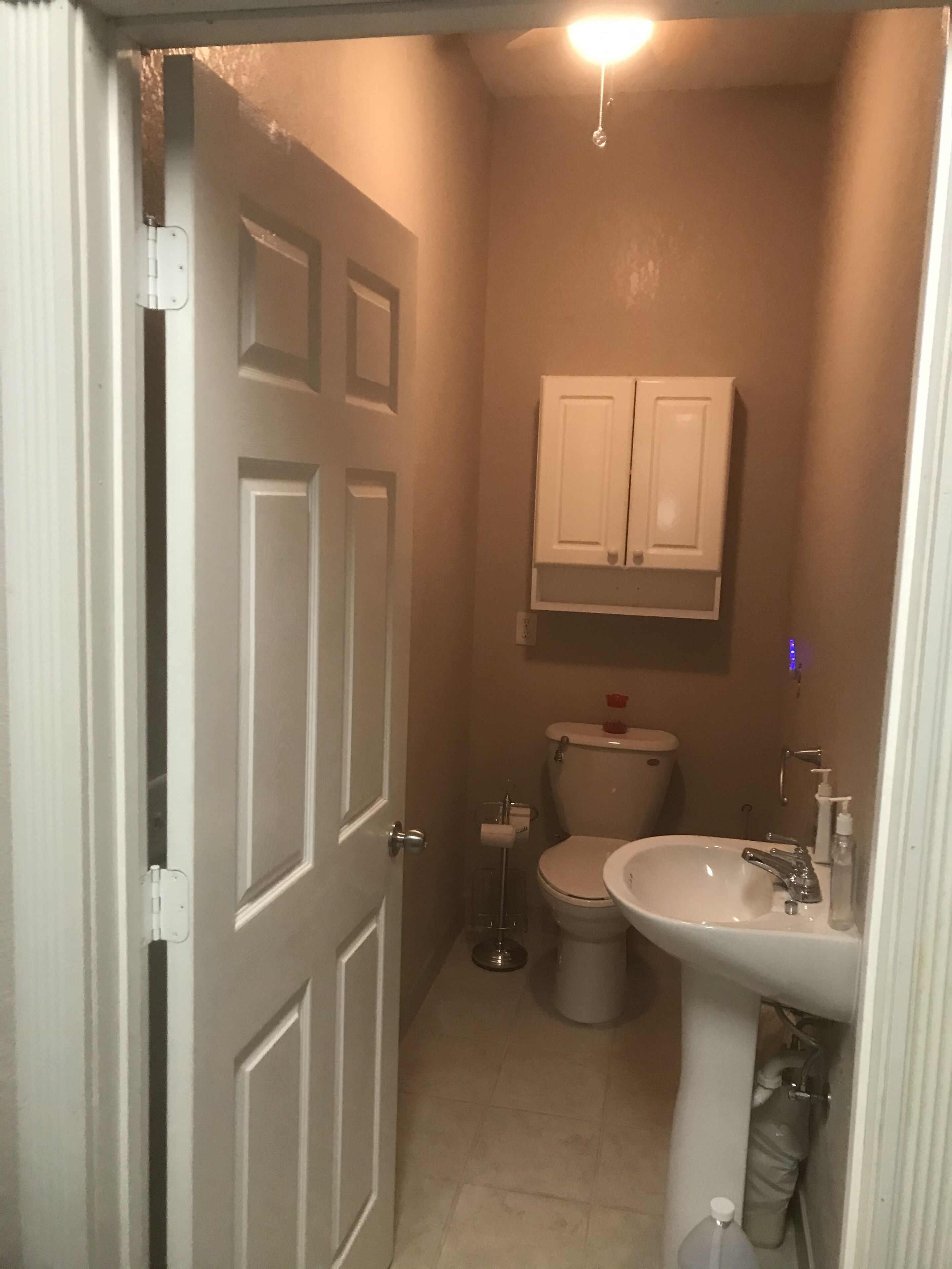 A compact bathroom with a toilet, sink, and cabinet.