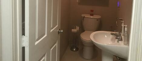 A compact bathroom with a toilet, sink, and cabinet.
