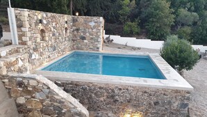 A stone-walled swimming pool with a stone deck surrounding it. - Chaihoutes stone villa into Olive farm in Zia (Kos)