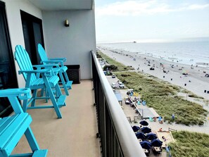 A balcony with blue Adirondack chairs, a view of the beach, and a pier in the distance. - Oceanfront Paradise in Cherry Grove Beach S. Carolina! (North Myrtle Beach)
