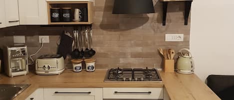 Een koelkast, een oven, een kookplaat, een koffiezetapparaat/waterkoker