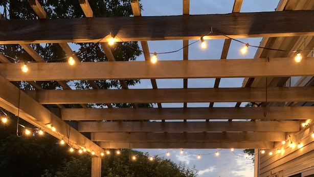 A wooden deck with a pergola, string lights, and outdoor furniture. - Vermont Gem Near Woodstock and Quechee (Woodstock)
