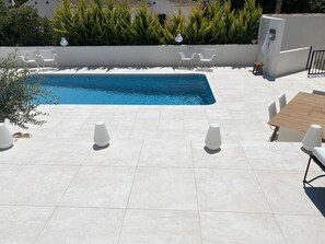 A poolside area with a rectangular pool, white outdoor furniture, and a tiled patio. - <br>CASA LIMON - Family Villa with private pool (Moraira)