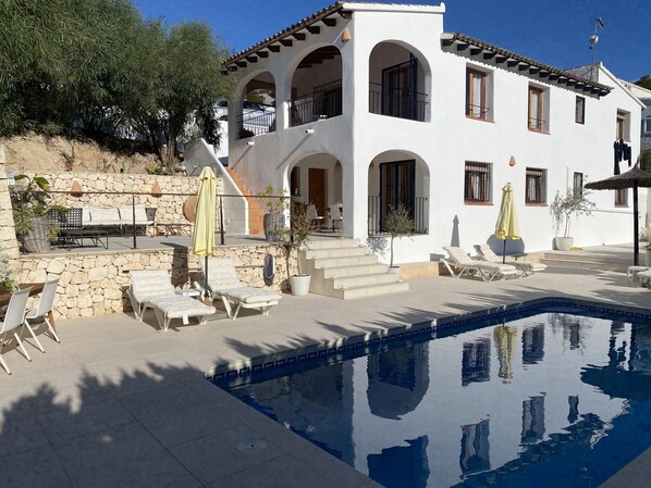 A white villa with a swimming pool, stone walls, and outdoor seating. - <br>CASA LIMON - Family Villa with private pool (Moraira)