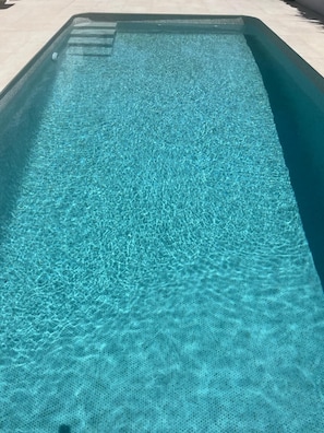 A rectangular swimming pool with clear water.