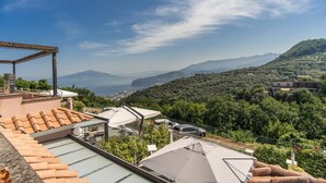 A rooftop terrace with a view of a mountainous landscape, a pergola, and a covered seating area. - Casa Filippo by Feeling Italy (Sant'Agata sui Due Golfi)