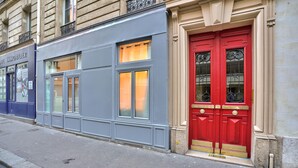 A building facade with a red door, a blue storefront, and a sign reading "IMMOBILIER". - NEW! Eiffel Tour Splendid 2BR apt in Paris (Paris)