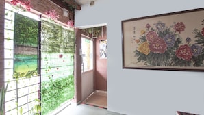 A room with a traditional Japanese-style sliding door, a tiled floor, and a large floral painting on the wall. - Spot On 90305 Hen Hen Hotel (Kulai)