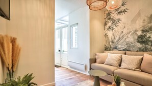 Un salon moderne avec un canapé, une table basse et une fresque murale.