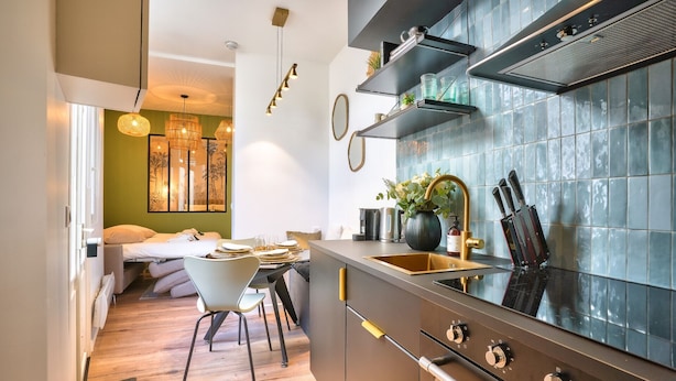 Une cuisine moderne dotée d’une grande cuisinière, d’un évier et d’un coin repas avec une table et des chaises.
