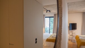 A bedroom with a bed, a TV, and a window. - FLH Intendente Blue Flat with Balcony (Lisbon)