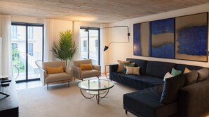 A modern living room with a sofa, armchair, coffee table, and a large window. - FLH Intendente Blue Flat with Balcony (Lisbon)
