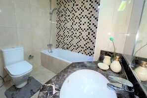 A bathroom with a toilet, bathtub, and sink. - Spacious 2BR with Direct Metro Access (Dubai)