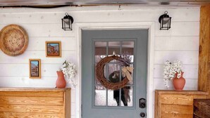 A front door with a wreath, two lanterns, and a wooden panel wall. - King Apt Suite  w/ Soaker Tub & Mountain Views (Bryson City)