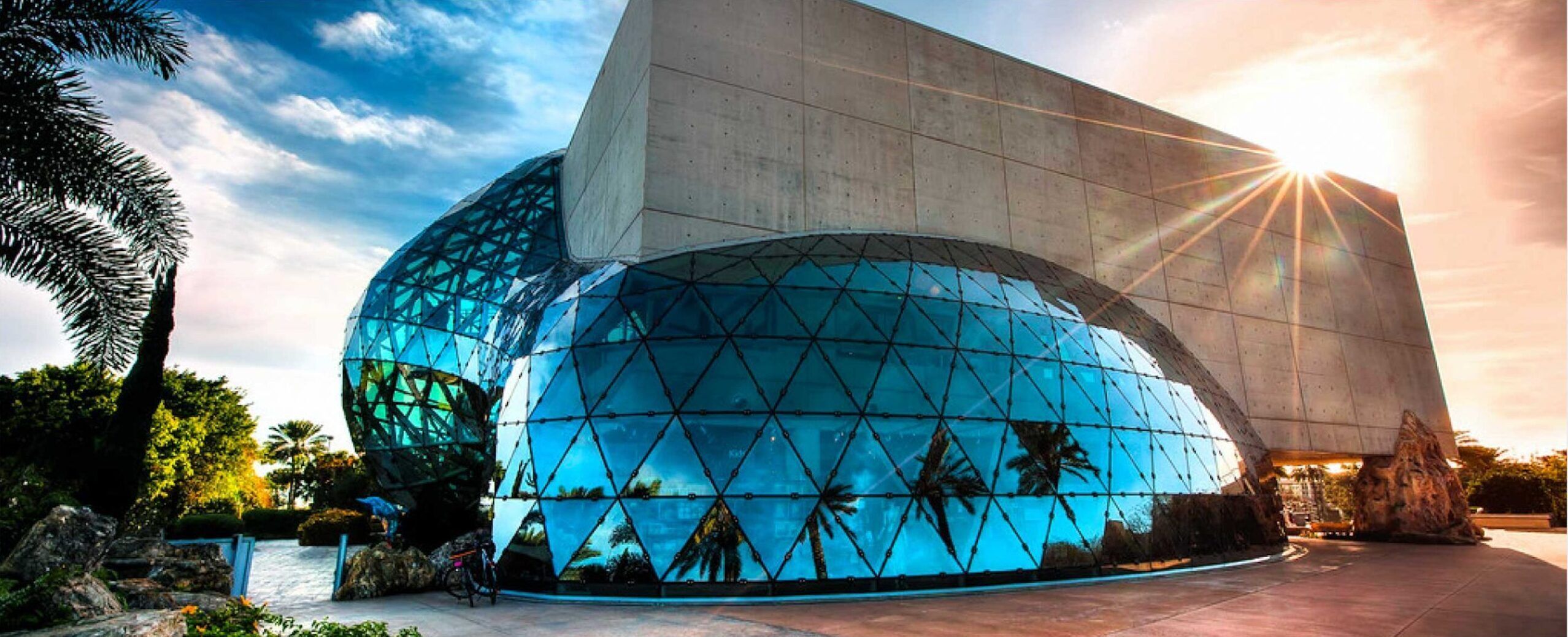 Un bâtiment moderne doté d’une grande façade en verre et d’un design géométrique.