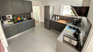 Una cocina moderna con armarios grises, horno integrado y ventana.
