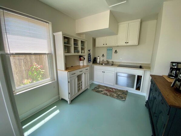 A kitchen with white cabinets, a built-in oven, and a window with blinds. - Walk To The Beach At Beacon Hill. (Port St. Joe)