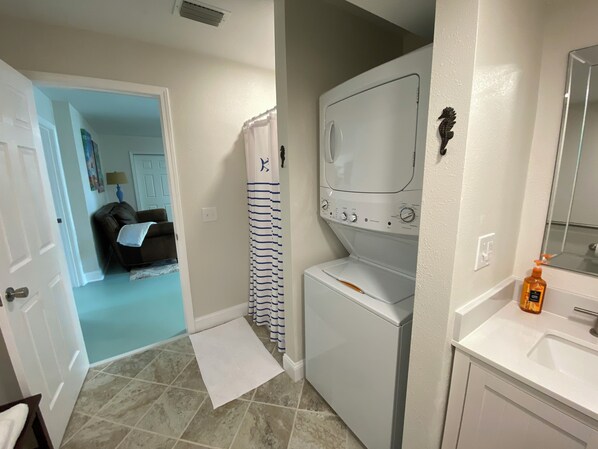 A laundry room with a washing machine, dryer, and a small sink with a mirror. - Walk To The Beach At Beacon Hill. (Port St. Joe)