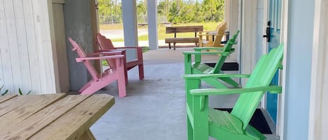 A covered outdoor seating area with wooden benches and picnic tables.