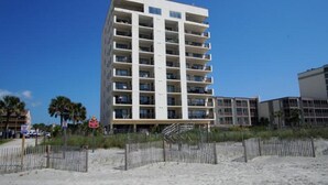 Ein mehrstöckiges Hotel mit Balkonen in Strandnähe.