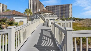 A wooden boardwalk leading to a building with a sign labeled "SECURITY".