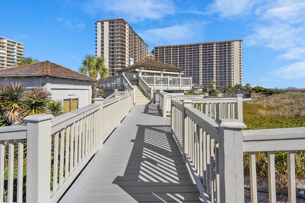 A wooden boardwalk leading to a building with a sign labeled "SECURITY".