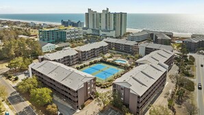 A coastal hotel complex with multiple buildings, a tennis court, and a pool. - Tilghman Beach & Racquet Club 264-3BR/2.5BA Condo IN Ocean Drive (North Myrtle Beach)
