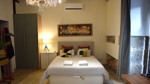 A bedroom with a large bed, a chandelier, a painting, and a wardrobe. - Cozy Studio st Level in the Very Center of Madrid (Madrid)