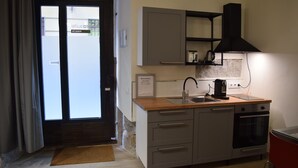 A compact kitchen with a sink, stove, and cabinets. - Cozy Studio st Level in the Very Center of Madrid (Madrid)