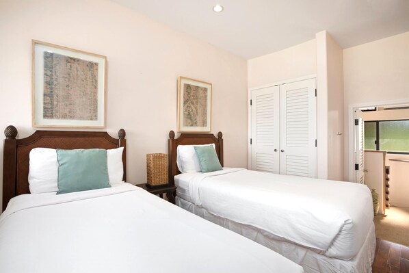 Une chambre d’hôtel avec deux lits, une armoire et une fenêtre.