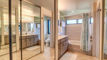 A modern bathroom with a glass-enclosed vanity, a separate shower area, and a bathtub.