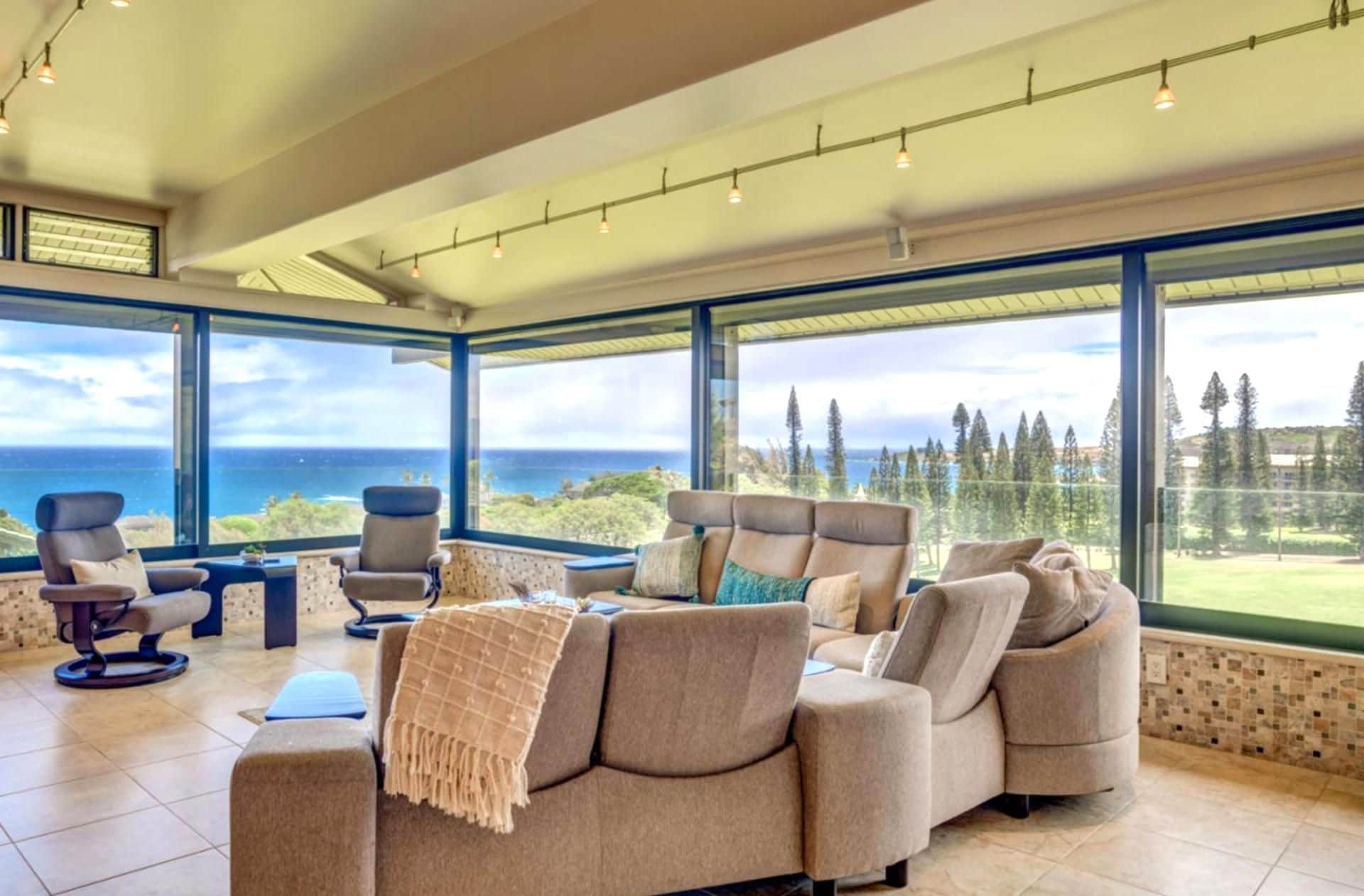 A spacious living area with a large window offering a view of the ocean and trees.