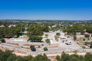 A historical site with ruins, a swimming pool, and surrounding greenery.