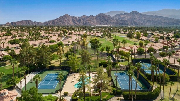 A resort with multiple tennis courts, pools, and a mountainous backdrop. - Luxury Condo - Tranquil Desert Retreat  (Palm Desert)